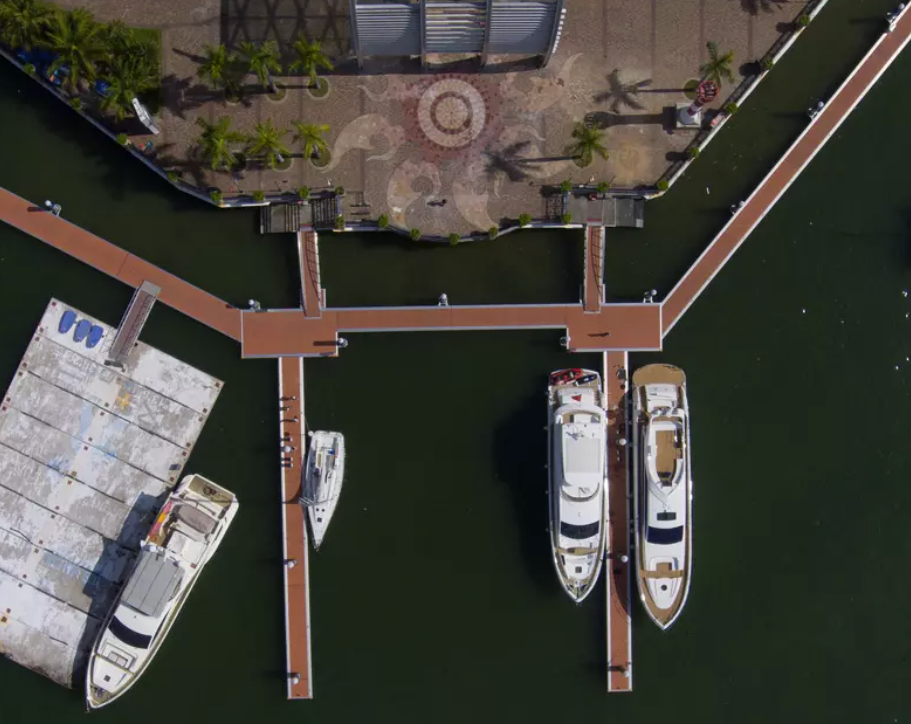 A floating dock on calm waters, with sturdy pontoons supporting a wooden platform, ideal for boat docking and recreational use.